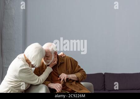 senior woman touching face and hugging husband sick on dementia Stock Photo