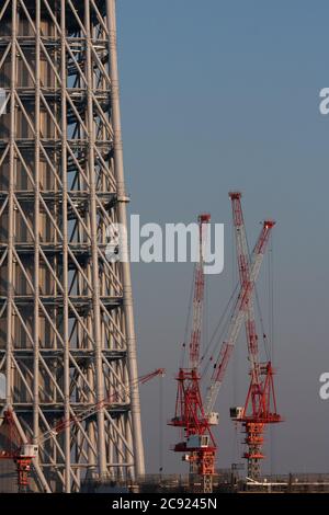 Cranes at the Tokyo Skytree construction site in Japan.Tokyo Sky Tree under construction. In this image this new telecommunication tower stands at 398 metres and when finished will measure 634 metres from top to bottom making it the tallest structure in East Asia. Oshiage, Tokyo, Japan. Stock Photo