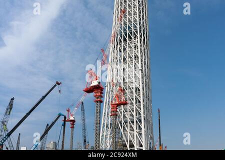 Tokyo, Japan. 21st June, 2010. Cranes at the Tokyo Skytree construction site in Japan.Tokyo Sky Tree under construction. In this image this new telecommunication tower stands at 398 metres and when finished will measure 634 metres from top to bottom making it the tallest structure in East Asia. Oshiage, Tokyo, Japan. Credit: Damon Coulter/SOPA Images/ZUMA Wire/Alamy Live News Stock Photo