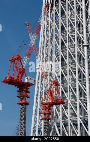 Tokyo, Japan. 21st June, 2010. Cranes at the Tokyo Skytree construction site in Japan.Tokyo Sky Tree under construction. In this image this new telecommunication tower stands at 398 metres and when finished will measure 634 metres from top to bottom making it the tallest structure in East Asia. Oshiage, Tokyo, Japan. Credit: Damon Coulter/SOPA Images/ZUMA Wire/Alamy Live News Stock Photo