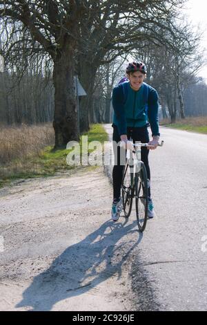 Kaliningrad region, Russia, March 28, 2020. Bike fix, young cyclist on the road. The cyclist in the helmet smiles. Stock Photo
