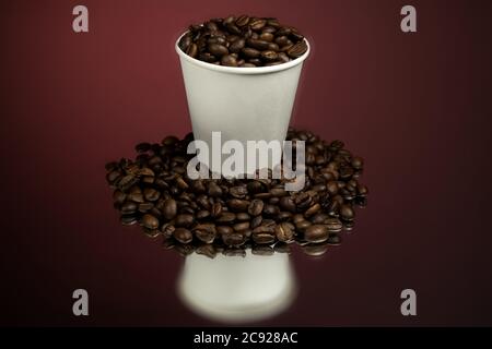 Paper cup of coffee and coffee beans on red Stock Photo