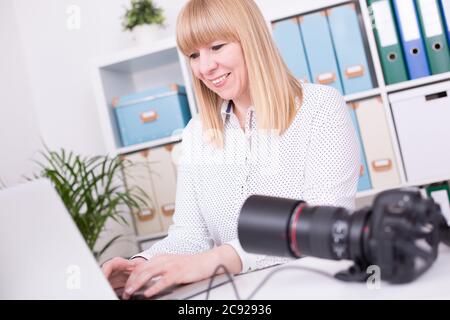Young Caucasian female photographer working in the office Stock Photo