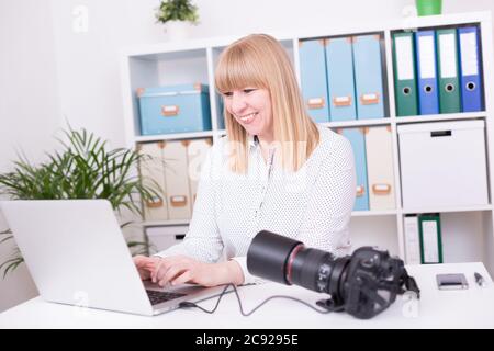 Young Caucasian female photographer working in the office Stock Photo