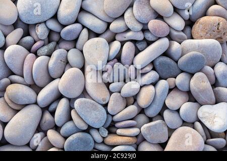Light blue and garnet smooth rocks on soft white rocks in outdoor natural landscape. Stock Photo