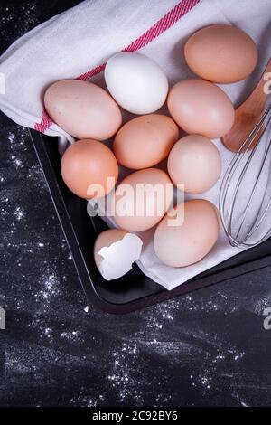Place a few healthy, broken eggs on a white cloth or in a bowl next to each other with a hand mixer. Stock Photo