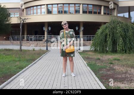 A mature woman in full growth against the background of a modern building Stock Photo