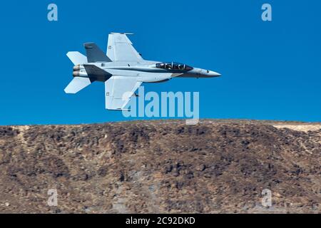US Navy F/A-18F Super Hornet Flying At Low Level and High Speed Through Rainbow Canyon, California, USA. Stock Photo