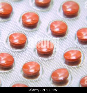 Blister with tablets close-up on a gray background. Pharmaceutical or medical background Stock Photo