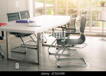 Black chairs in white conference room with sunlight. Stock Photo