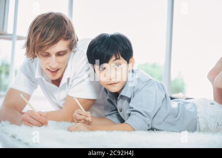 Father helping their son homework in the living room at home. Stock Photo
