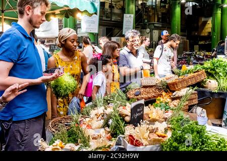 People Buying Fresh Vegetables From A Stall In Borough Market, London, England. Stock Photo