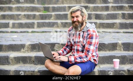 bearded man sit on stairs with laptop. online distant education. inspired to work with coffee. agile business. mature student working on computer. go shopping on cyber monday. Confident graduate. Stock Photo