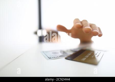 Man's hand reaches for paper bill and card Stock Photo