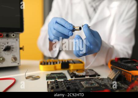 Master is holding bat and screwdriver lies next to hard drive Stock Photo