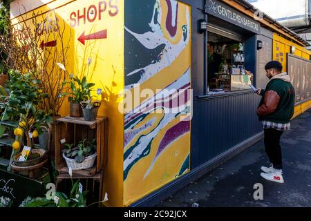 A Young Man Buying Coffee At A Coffee Shop In Vinegar Yard, London, England. Stock Photo