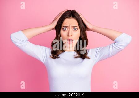 Photo of shocked attractive lady wavy hairdo listen bad news open mouth terrified eyes arms hold touch head wear casual white pullover isolated pastel Stock Photo