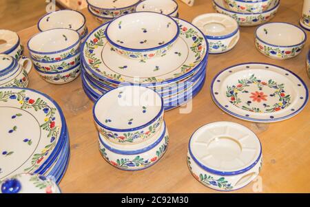 A set of painted ceramic dishes on the store counter, colorful plates and bowls. Stock Photo