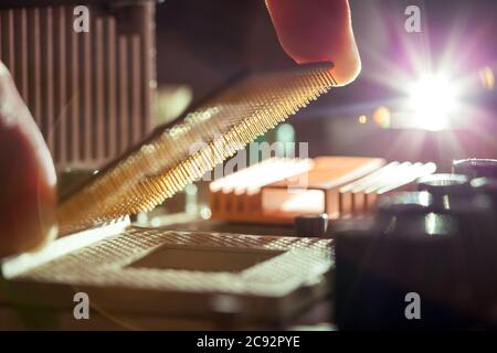 Technician plug in CPU microprocessor to motherboard socket, evident process of installation. Stock Photo