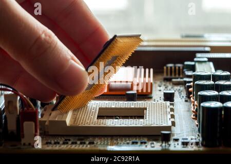 Technician plug in CPU microprocessor to motherboard socket, evident process of installation. Stock Photo