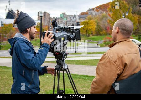 MONTREAL, CANADA - Oct 16, 2010: Montreal, Quebec / Canada - October 16 2010: Cameraman Using Panasonic Shoulder Mount Camera on a Tripod next to a Sh Stock Photo