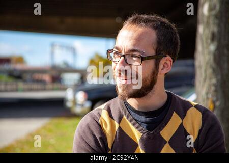 MONTREAL, CANADA - Oct 16, 2010: Montreal, Quebec / Canada - October 16 2010: Young Caucasian Man Using Glasses and Wearing a Yellow and Brown Sweater Stock Photo