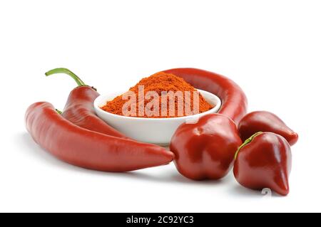 Red hot chili peppers pods and pepper in powder in a bowl isolated on white background. Full depth of field stacked image. Stock Photo