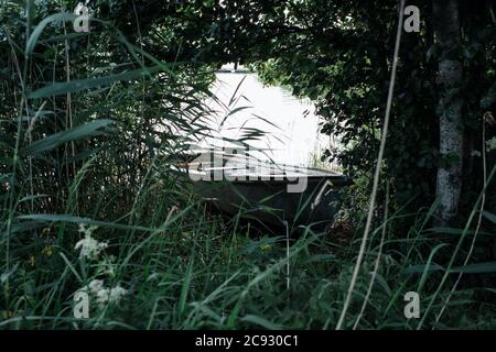 rowing boat on the water surrounded by foliage in summer Stock Photo