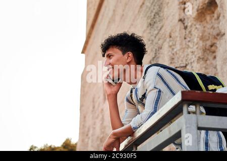 Young man with afro hair is using his smartphone outdoors Stock Photo