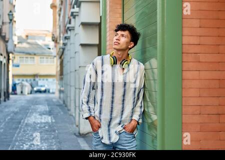 Young afro-haired man with headphones looks up Stock Photo