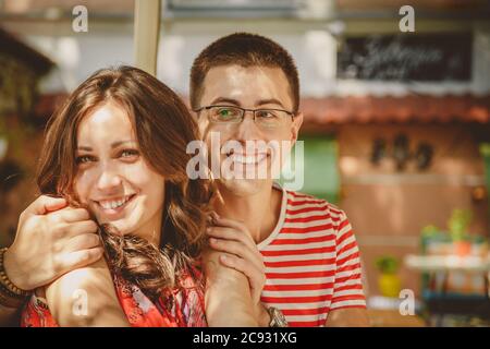 Close-up of young beautiful happy loving couple sitting at street open-air cafe. Beginning of love story. Relationship love, lifestyle concept. Couple Stock Photo