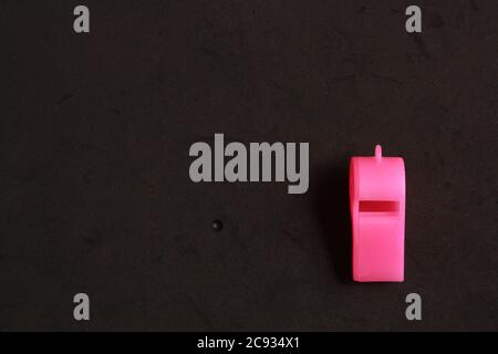 Pink whistle shaped plastic toy in black background Stock Photo