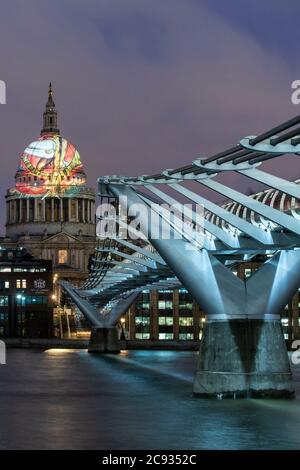 St.Paul's dome illuminated with graphic representing William Blake's Ancient of Days, Millennium Bridge in the foreground. St. Paul's Cathedral, Londo