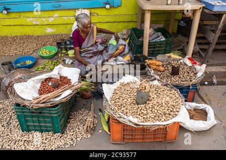 Trichy, Tamil Nadu, India - February 2020: An elderly Indian woman selling groundnuts and pulses and vegetables on the pavements of the streets of the Stock Photo