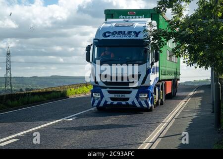 Iveco Stralis pulling a curtainsider trailer driving along the A628 Woodhead Pass in Yorkshire on a sunny Summer afternoon Stock Photo