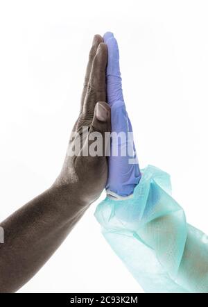 Vertical shot of a black man and a doctor touching hands on an isolated background Stock Photo