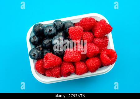 Independence day, happy fourth of july and sweet dessert concept with close up on the american flag made of raspberries and blueberries, isolated on m Stock Photo