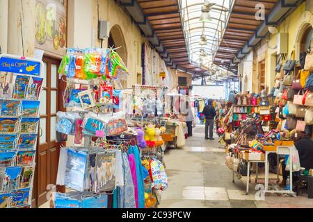 PAPHOS, CYPRUS - FEBRUARY 16, 2019: Colorful gifts magnets, kitchen towels on stands at souvenir market in Larnaca touristic downtown Stock Photo