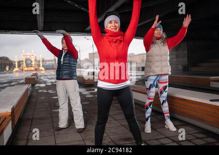 Older Adults Active in Sports and Fitness. Middle Aged Women Exercising Outdoors in at Park. Six Feet Of Social Distance Space Between Individuals Stock Photo