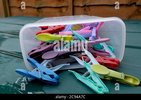 coloured plastic washing line pegs in a plastic peg box displayed in a exterior setting sturry east kent uk july 2020 Stock Photo