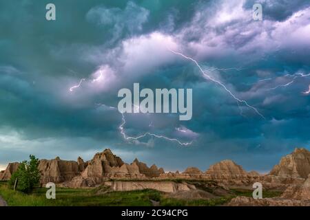 An active lightning storm over the mountains of Badlands National Park in South Dakota lights up the sky. Stock Photo
