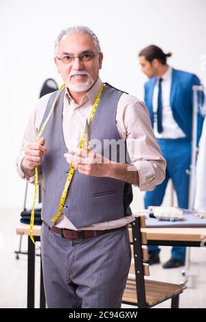 Young businessman visiting old tailor Stock Photo