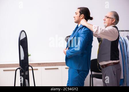 Young businessman visiting old tailor Stock Photo