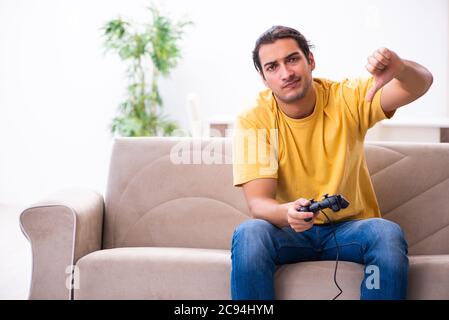 Young man playing joystick games at the home Stock Photo