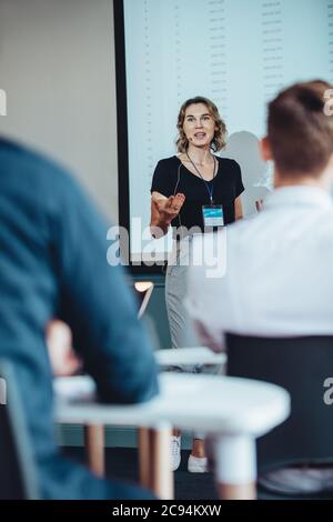 businesswoman giving a speech in modern conference room. Manager giving new business presentation to team in office. Stock Photo