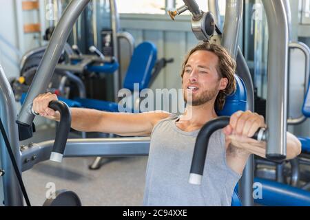 Man doing chest exercises on vertical bench press machine Stock Photo