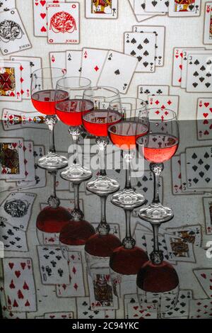 Still life with glasses of red wine on the background of playing cards Stock Photo