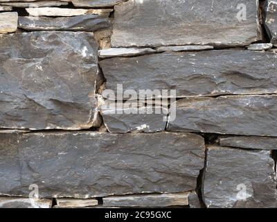 closeup of black stone wall, texture, background Stock Photo