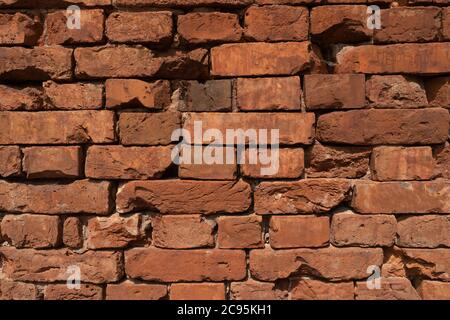 background from very old red brickwork. Wall without cement joints. Stock Photo