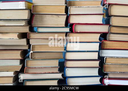 Stack of books background. a lot of books. A stack of books of different thicknesses in the library, a pile of old books, back to school Stock Photo